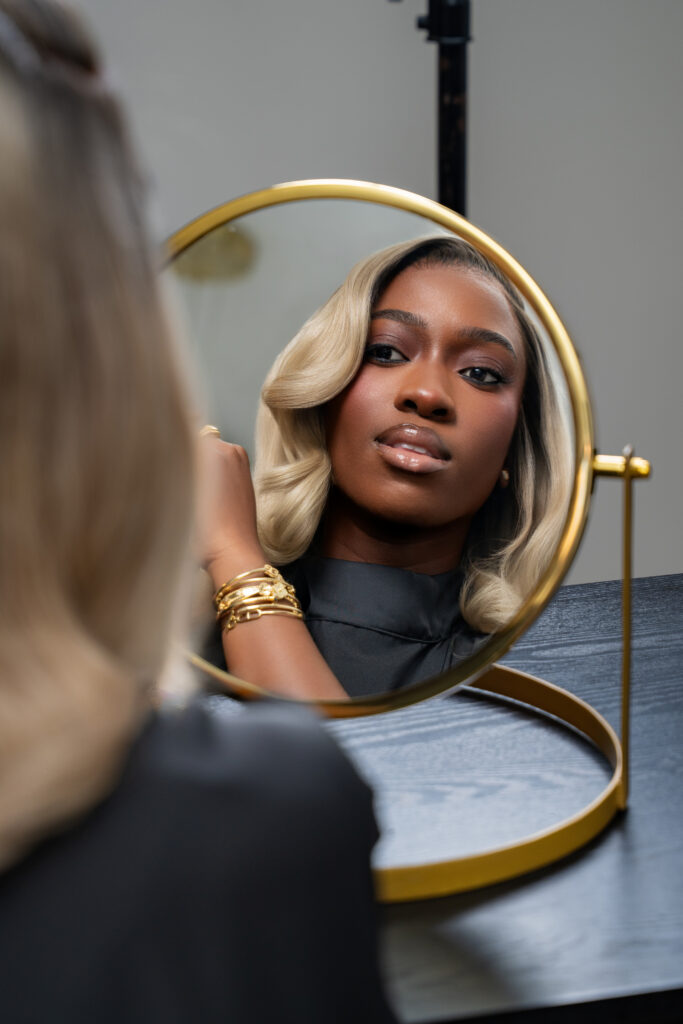 pose de perruque blonde sur une femme de teint noire